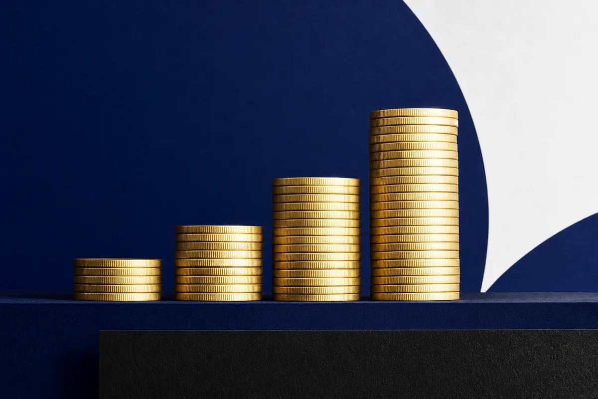Um gráfico de barras ascendente com moedas de ouro empilhadas ao lado, simbolizando crescimento financeiro.